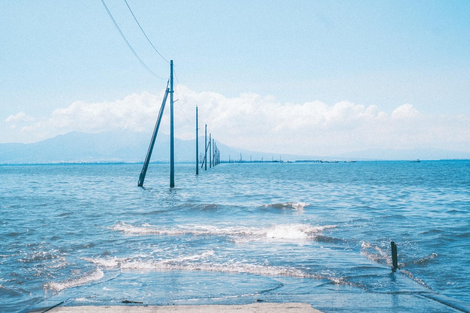 海に電柱が立っている写真