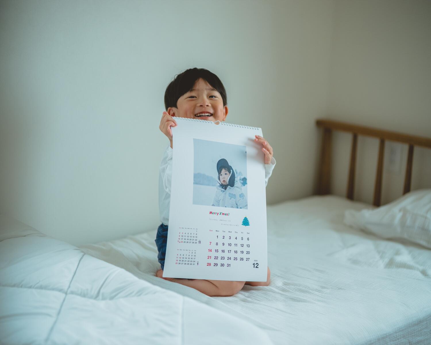 作ったカレンダーを持って嬉しそうな久慈さんの息子さん