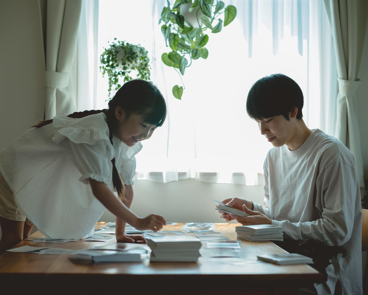 久慈さんの夫と娘さんが楽しげに写真を選んでいる様子